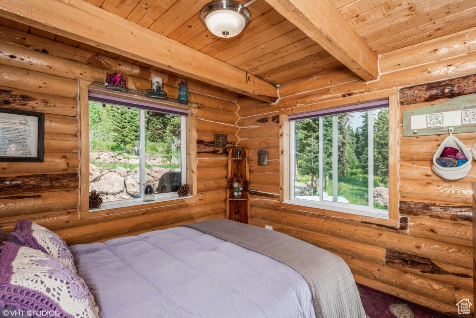 Bedroom with wood ceiling with exposed beams