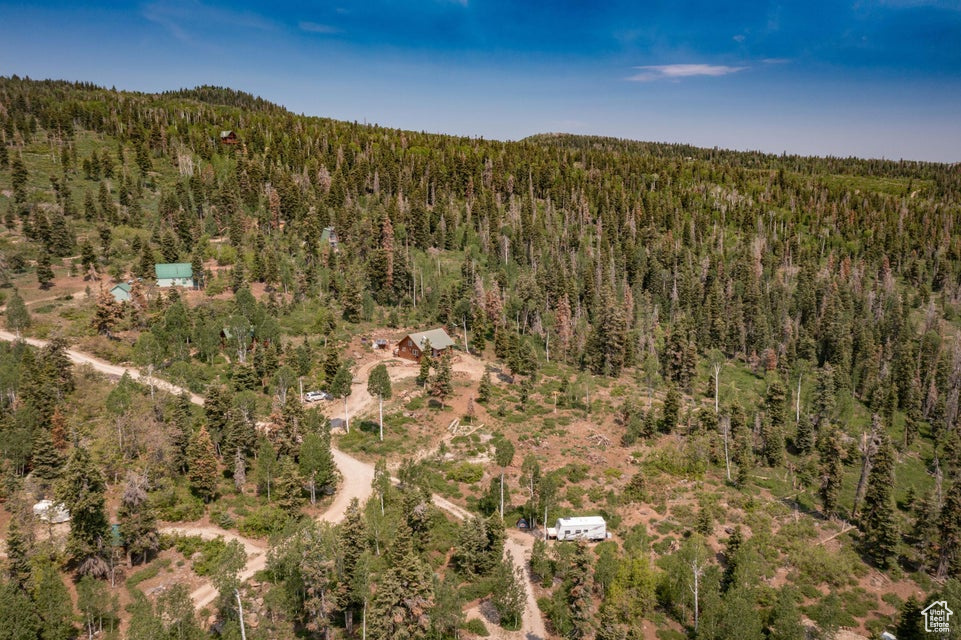 Aerial view of property and surrounding area with a heavily wooded area