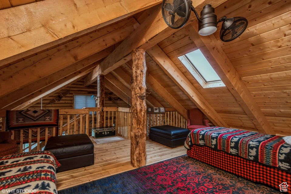 Bedroom with a skylight, hardwood / wood-style flooring, and wood ceiling