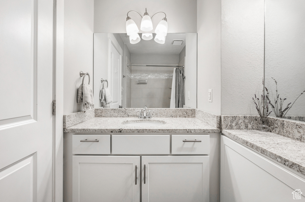 Bathroom featuring vanity, a chandelier, and a shower with curtain