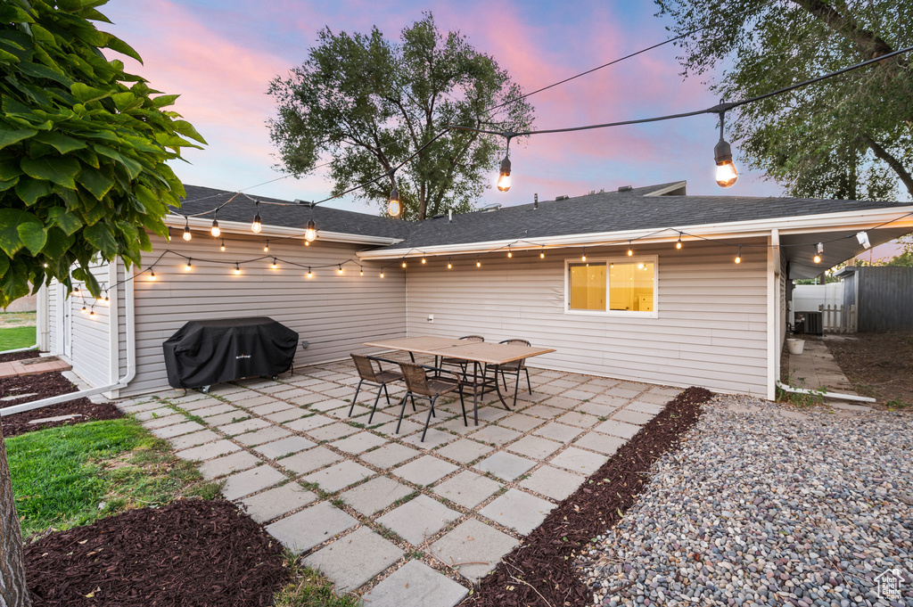 Patio terrace at dusk featuring a patio area, a grill, and central AC