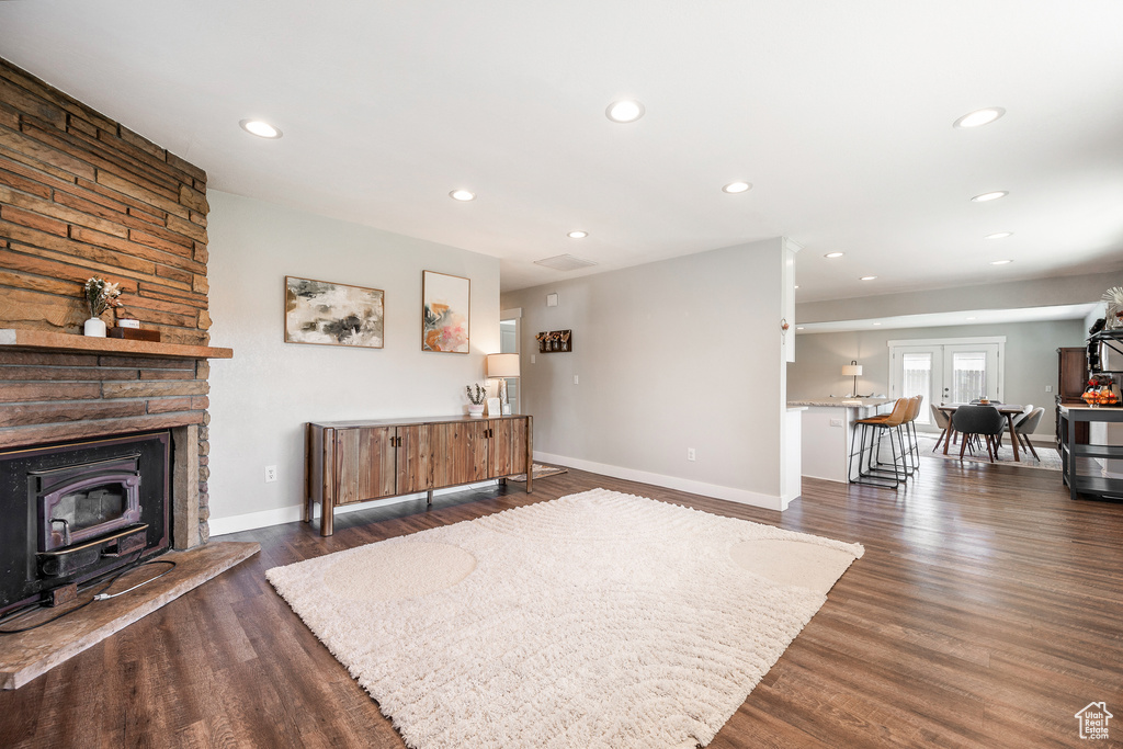 Living room featuring dark wood-type flooring, baseboards, recessed lighting, and french doors