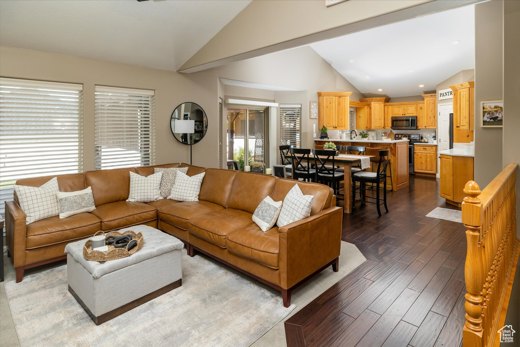 Living area with lofted ceiling, dark wood-style flooring, and recessed lighting