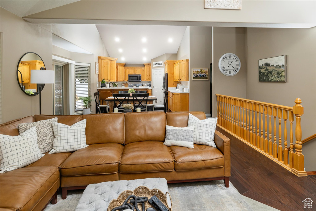 Living area featuring vaulted ceiling, wood finished floors, baseboards, and recessed lighting