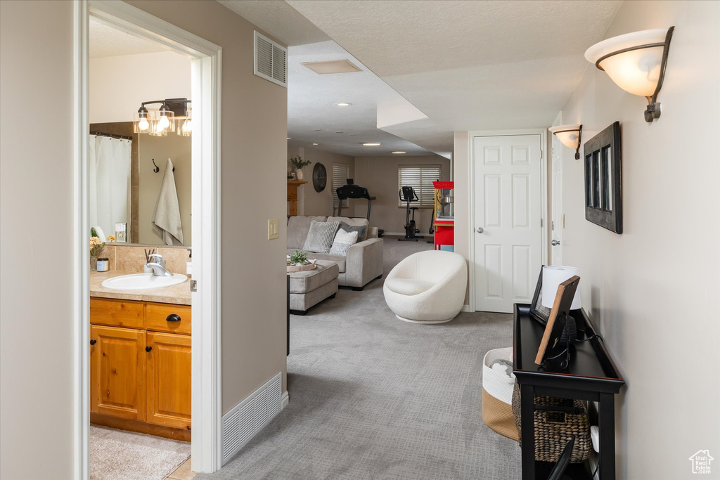 Hall with a sink and light carpet