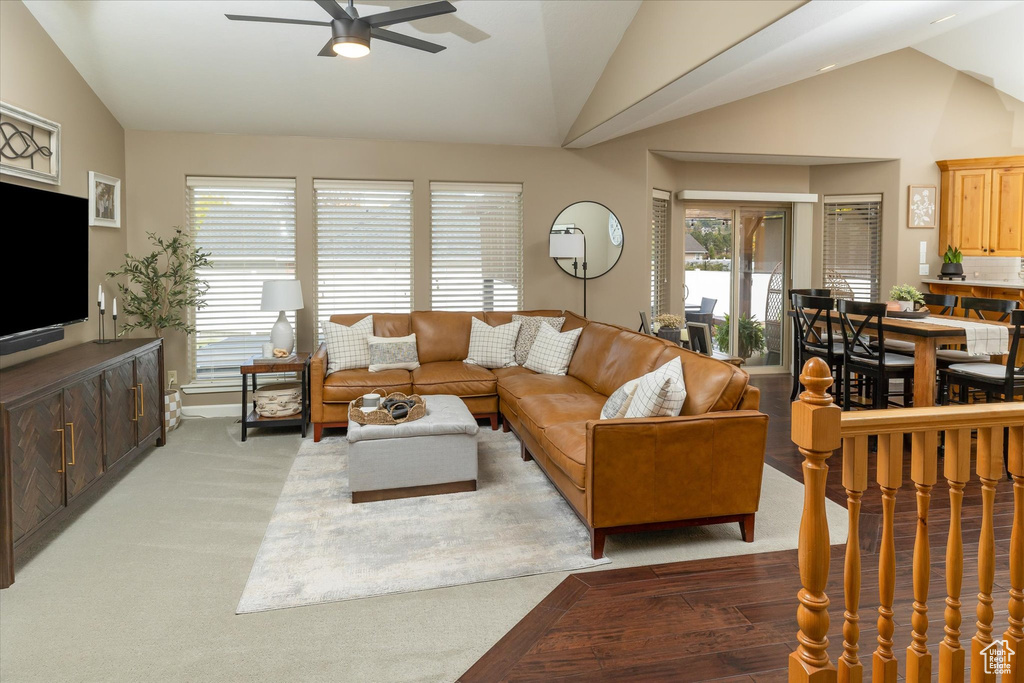 Living area with vaulted ceiling, ceiling fan, and light wood finished floors