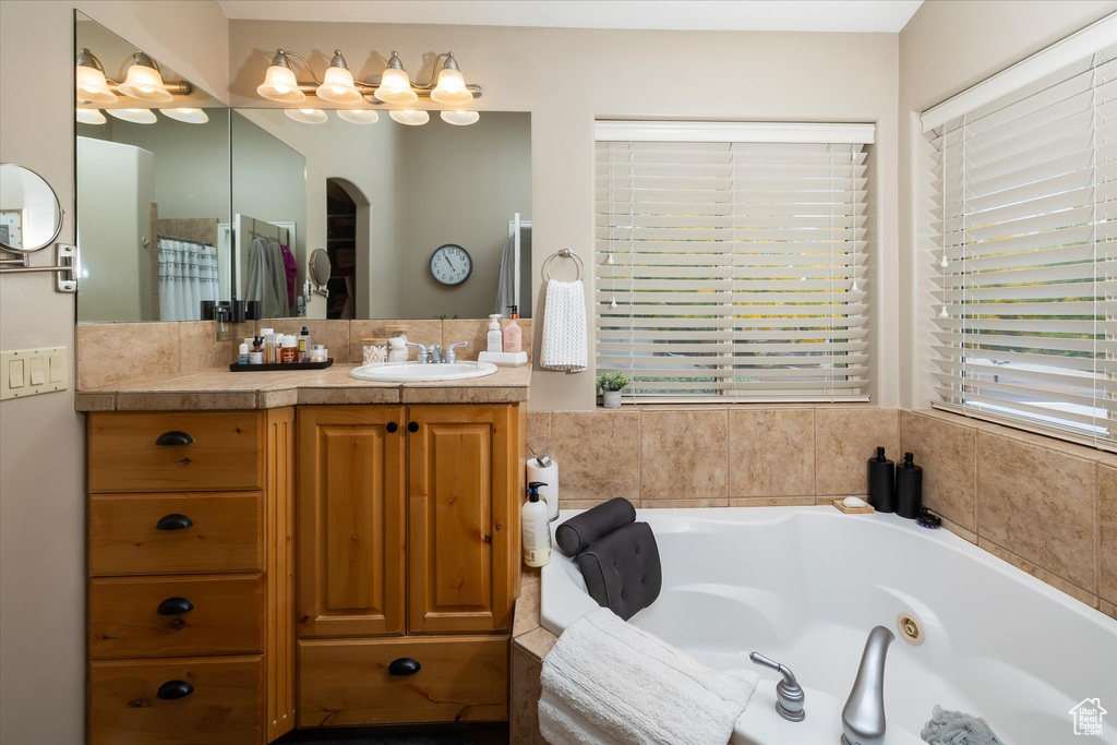 Bathroom featuring vanity and a tub with jets