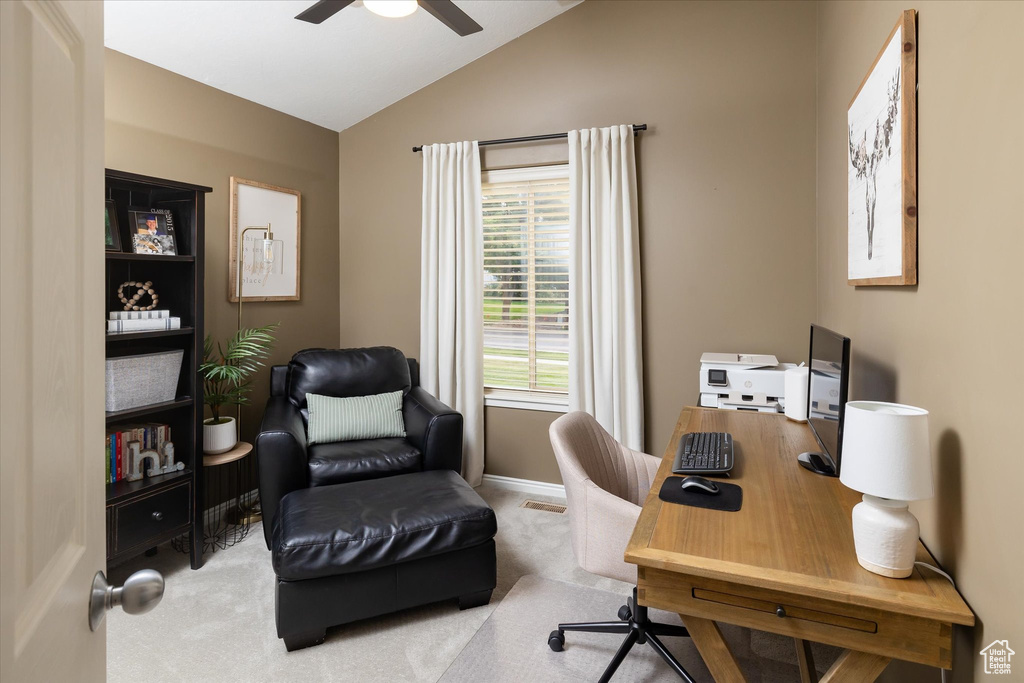 Carpeted home office featuring vaulted ceiling, a ceiling fan, and baseboards