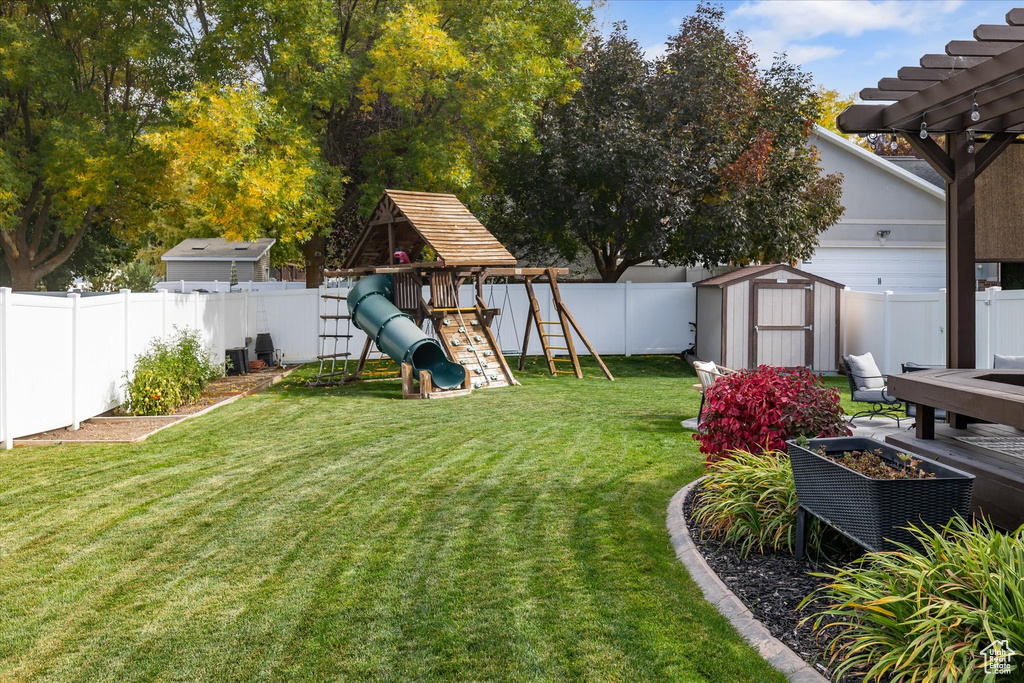 View of yard with a playground and a pergola
