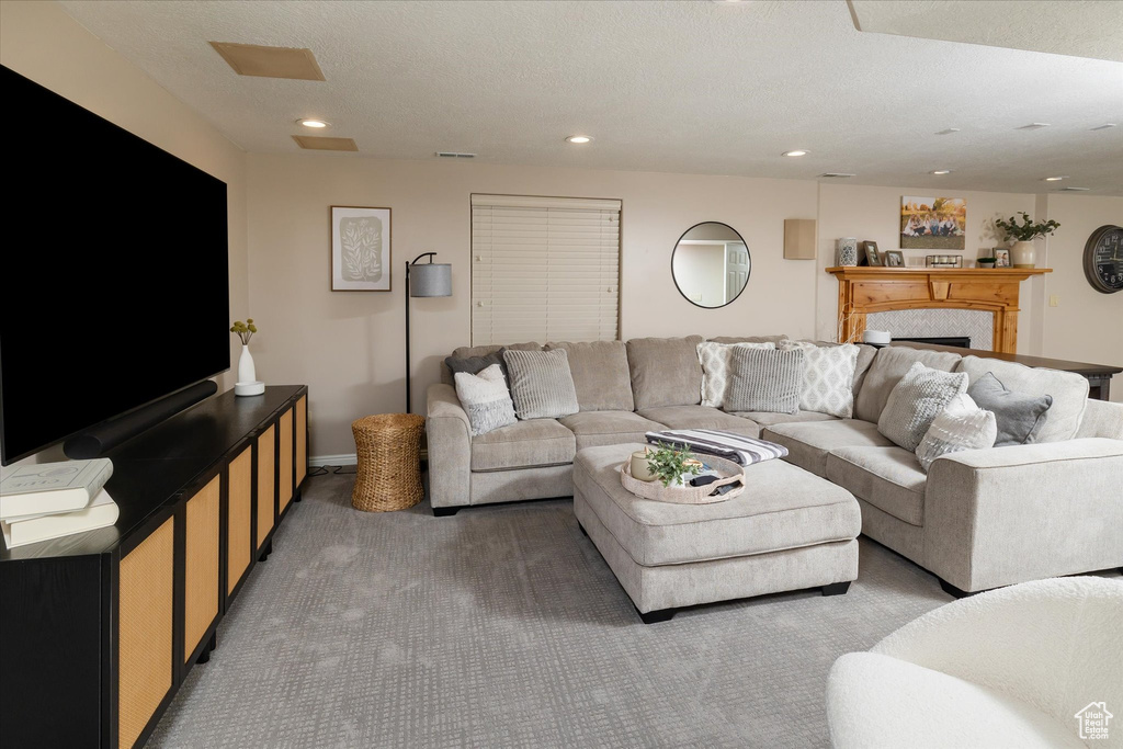 Living area with carpet flooring, a fireplace, and recessed lighting