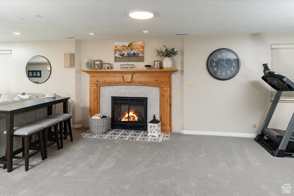 Exercise area featuring carpet floors, a tile fireplace, baseboards, and recessed lighting