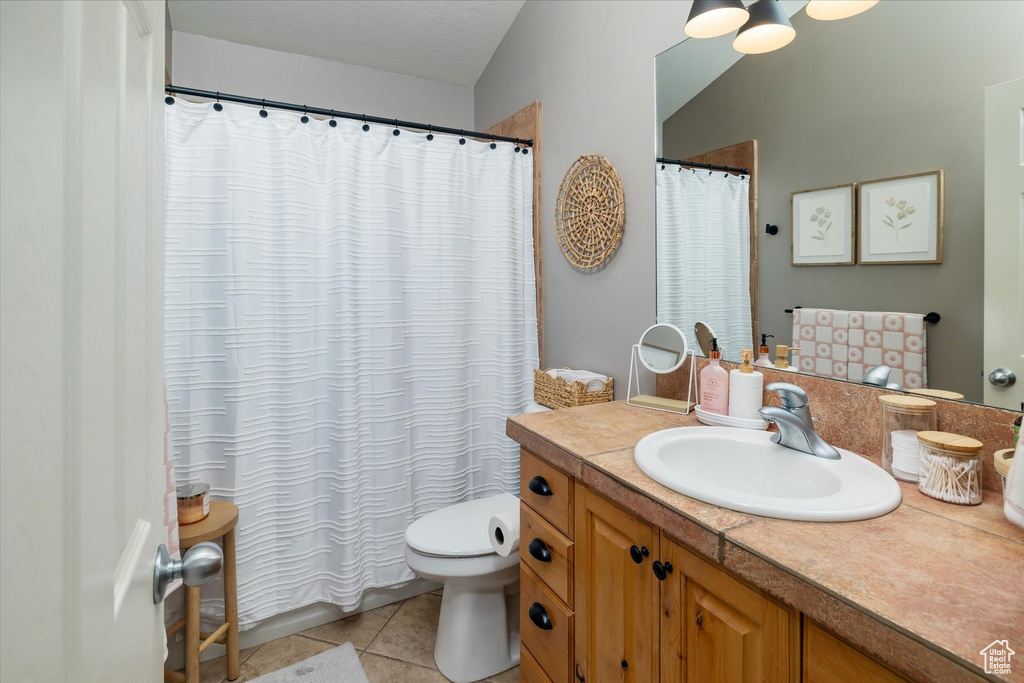 Full bathroom featuring vanity, toilet, tile patterned flooring, and a shower with curtain