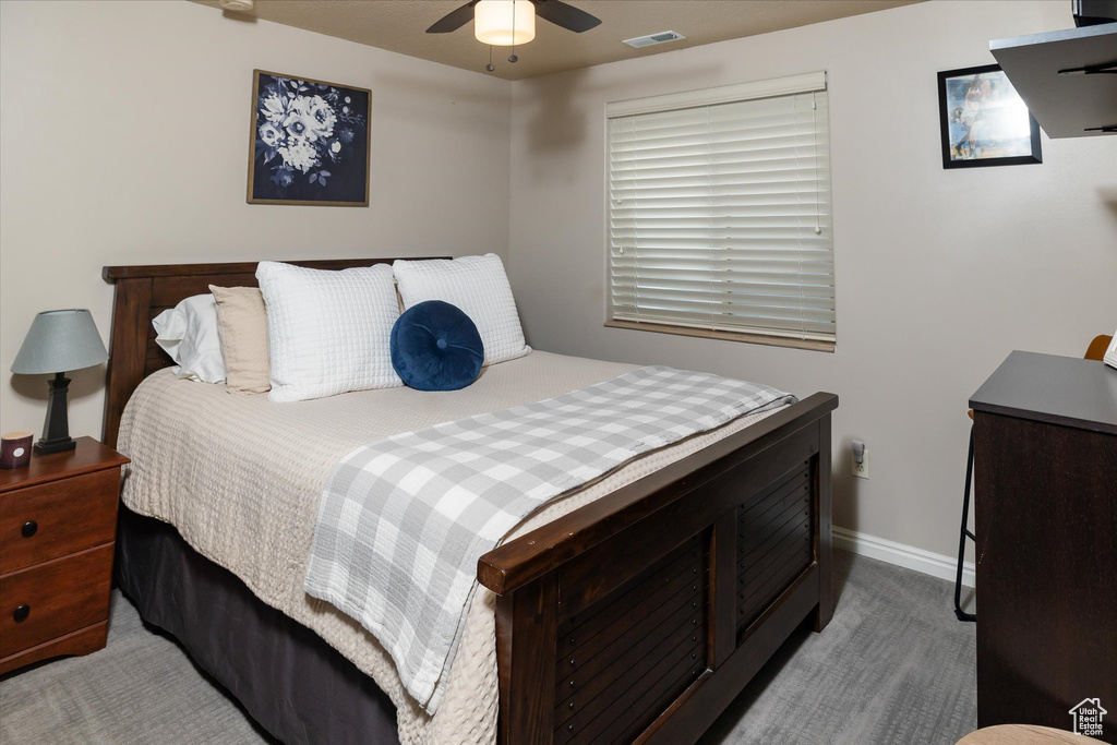 Carpeted bedroom featuring baseboards and ceiling fan