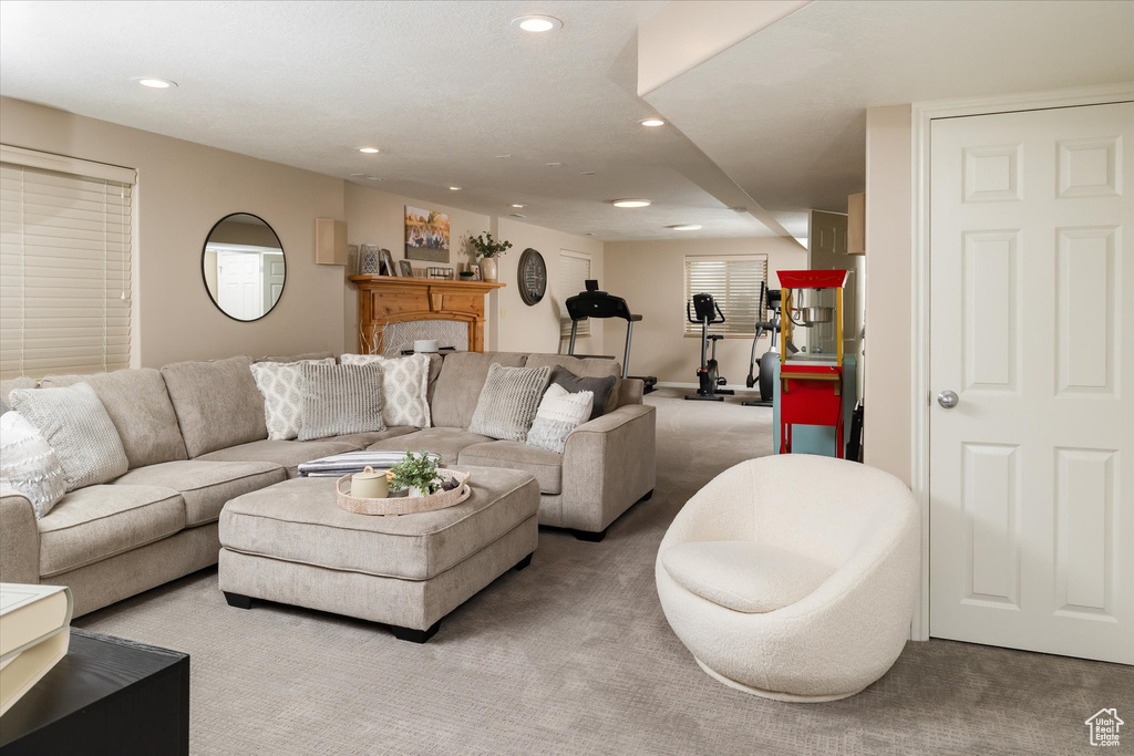 Living room with light colored carpet, recessed lighting, and a fireplace