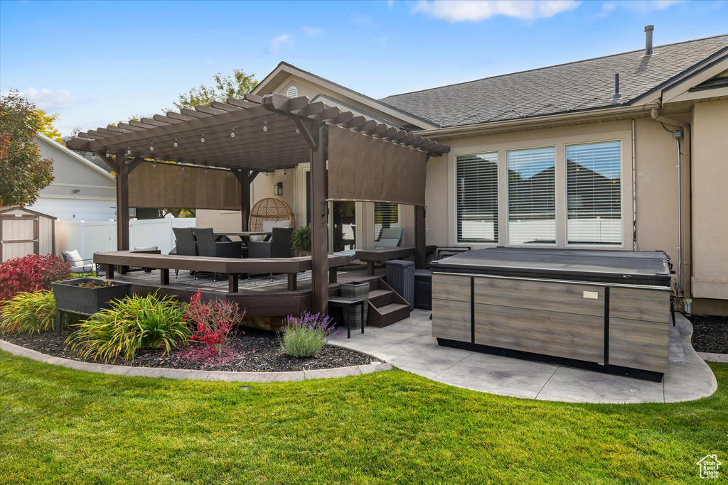 Rear view of house featuring a hot tub, a patio, a pergola, an outdoor hangout area, and stucco siding