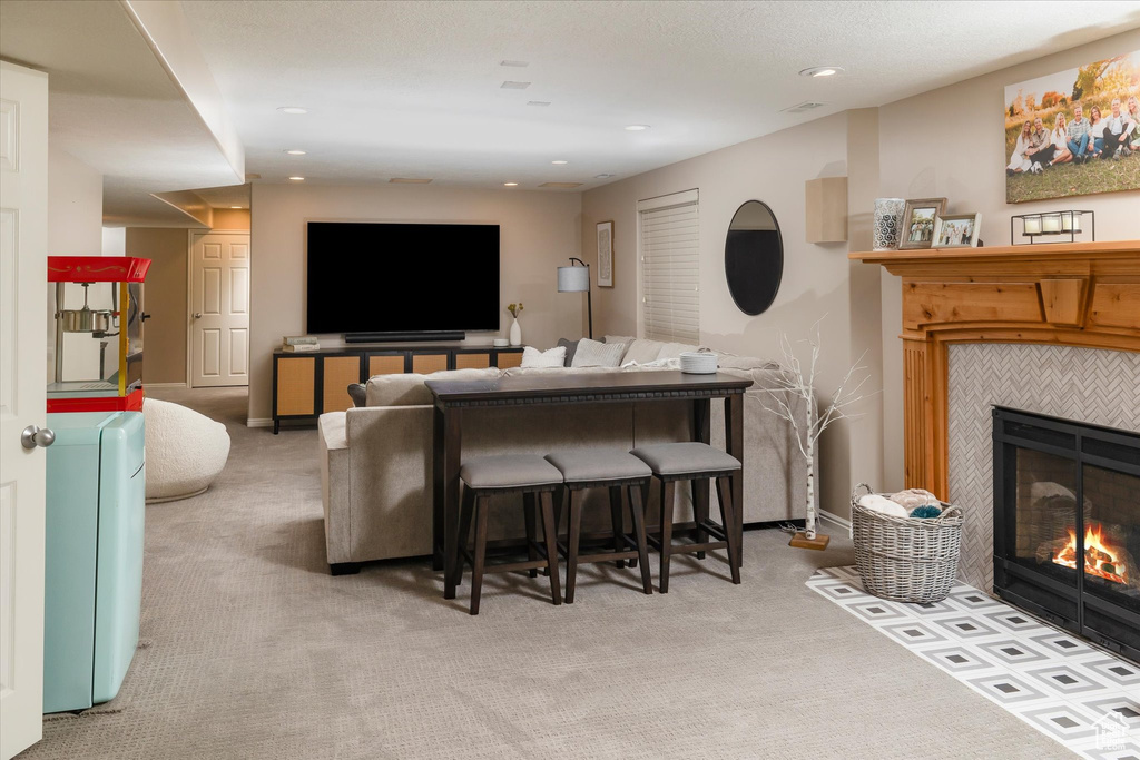 Living room featuring a tile fireplace, carpet flooring, and recessed lighting