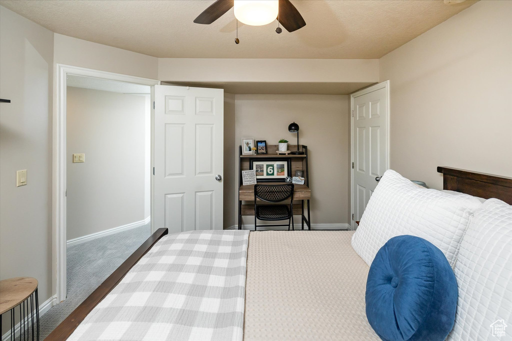 Carpeted bedroom featuring baseboards and a ceiling fan