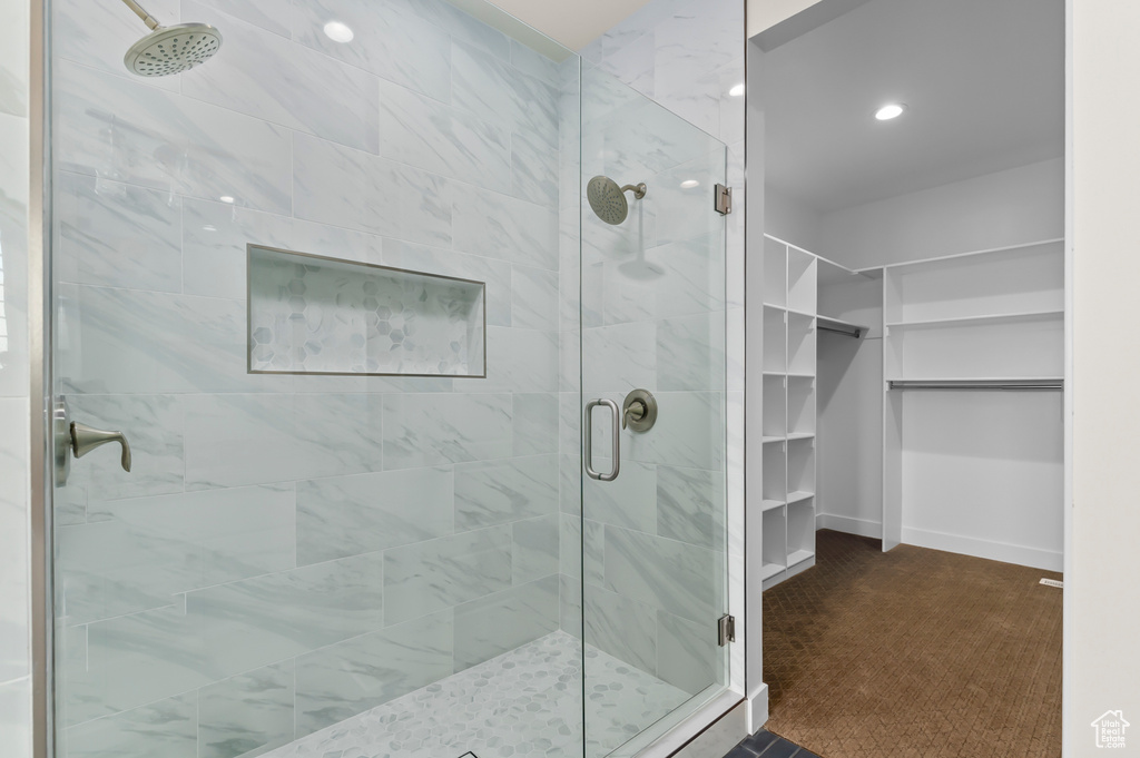 Full bathroom featuring a shower stall, a walk in closet, recessed lighting, and baseboards