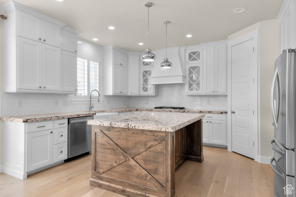 Kitchen featuring stainless steel appliances, light wood-style floors, white cabinetry, and recessed lighting