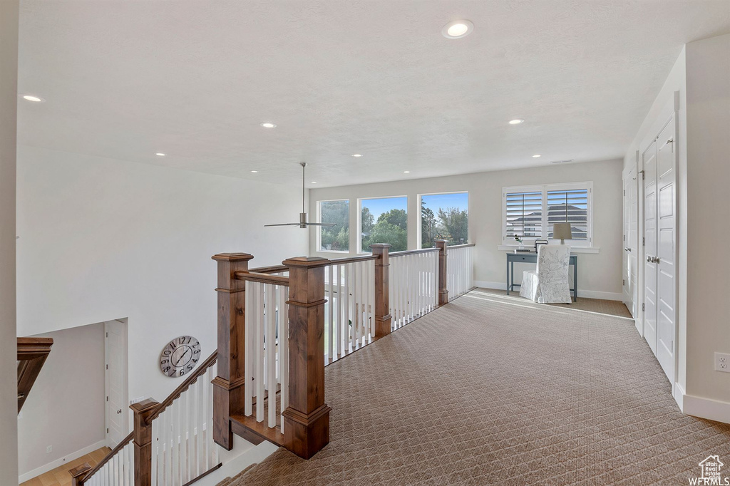Hallway with an upstairs landing, recessed lighting, baseboards, and carpet floors