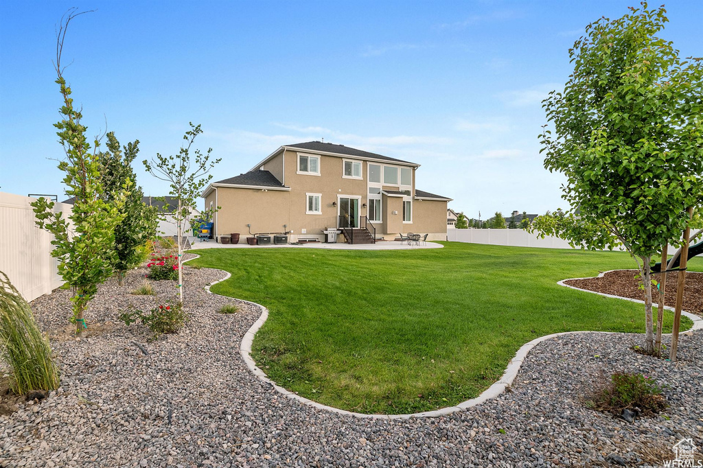 View of yard with entry steps and a patio area