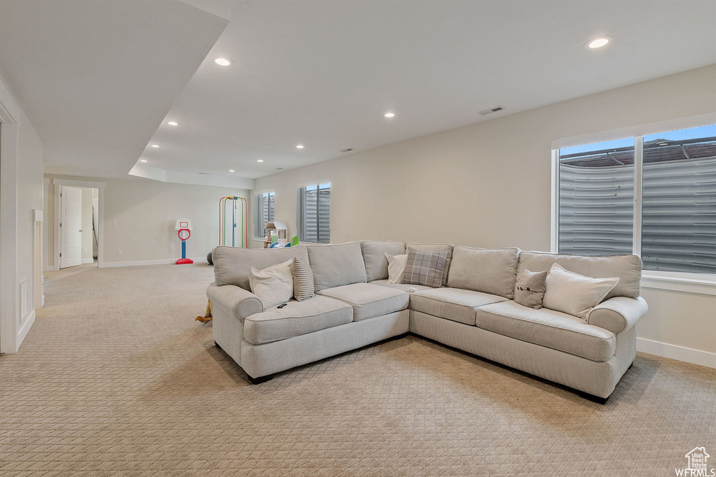 Living area featuring recessed lighting, baseboards, light carpet, and healthy amount of natural light