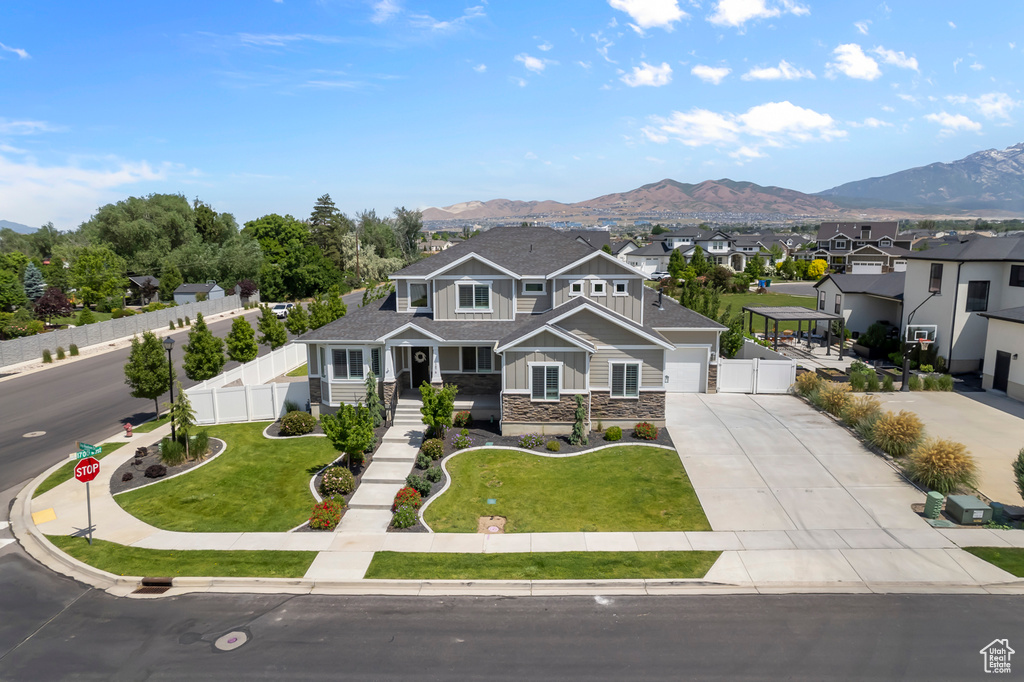 View of front of home featuring driveway, stone siding, a mountain view, and board and batten siding