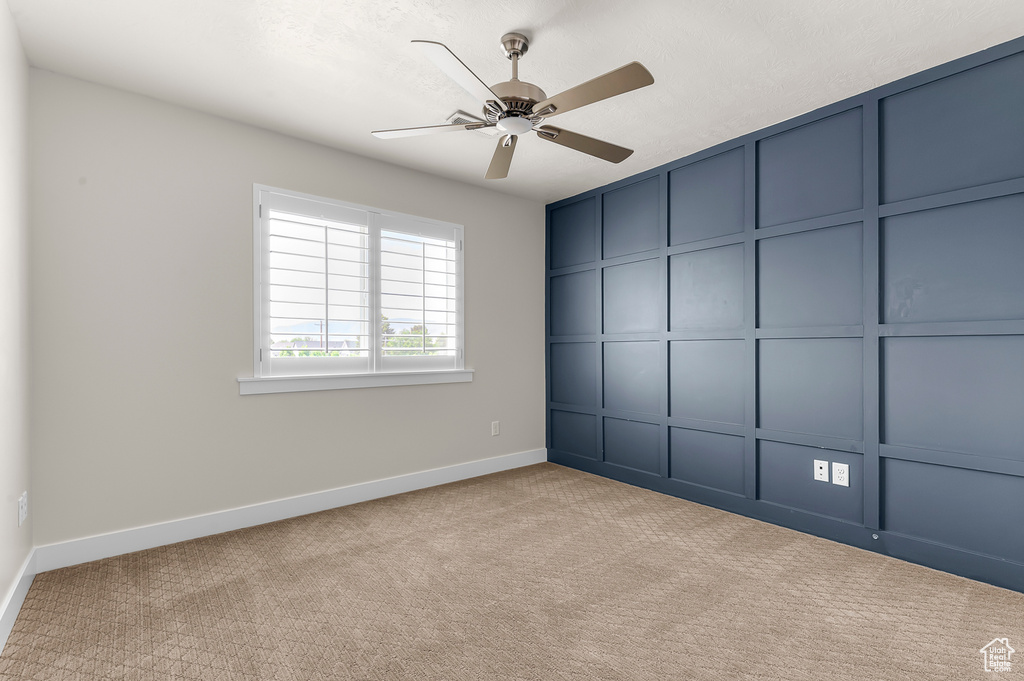 Unfurnished bedroom with baseboards, carpet, and a ceiling fan