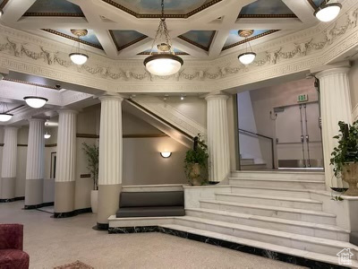 Building lobby with coffered ceiling, ornamental molding, and stairs