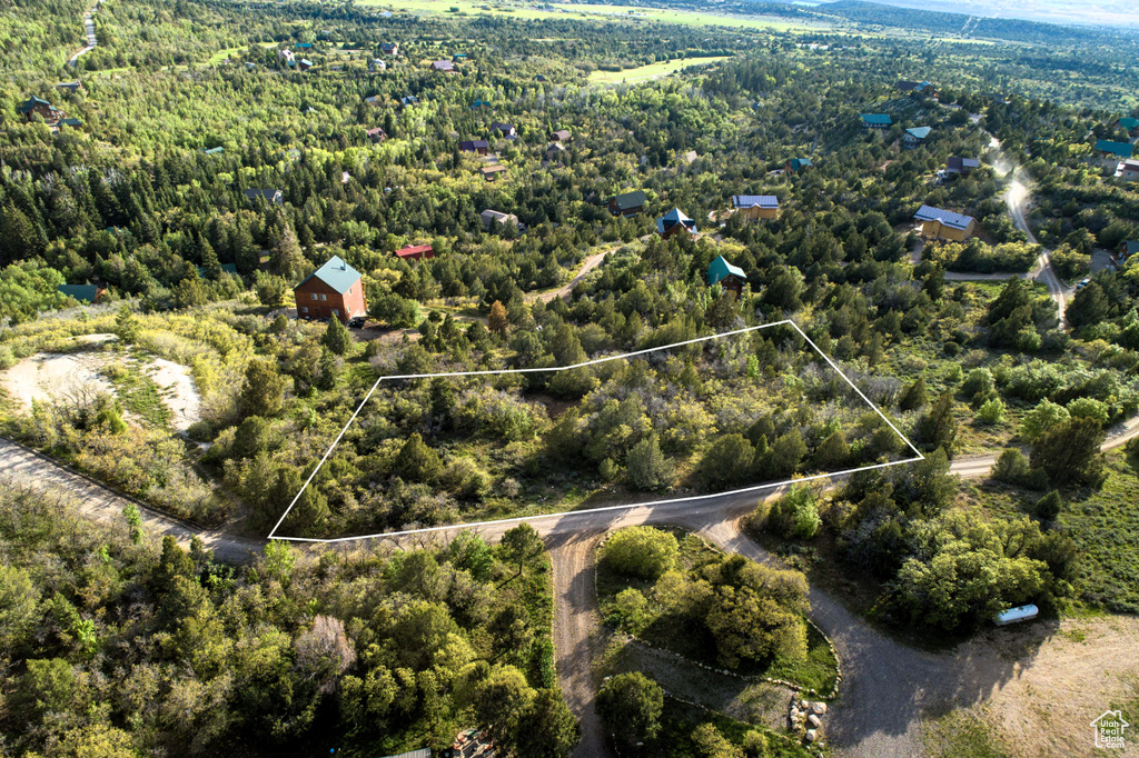 Aerial view of property and surrounding area featuring property boundaries highlighted and a heavily wooded area