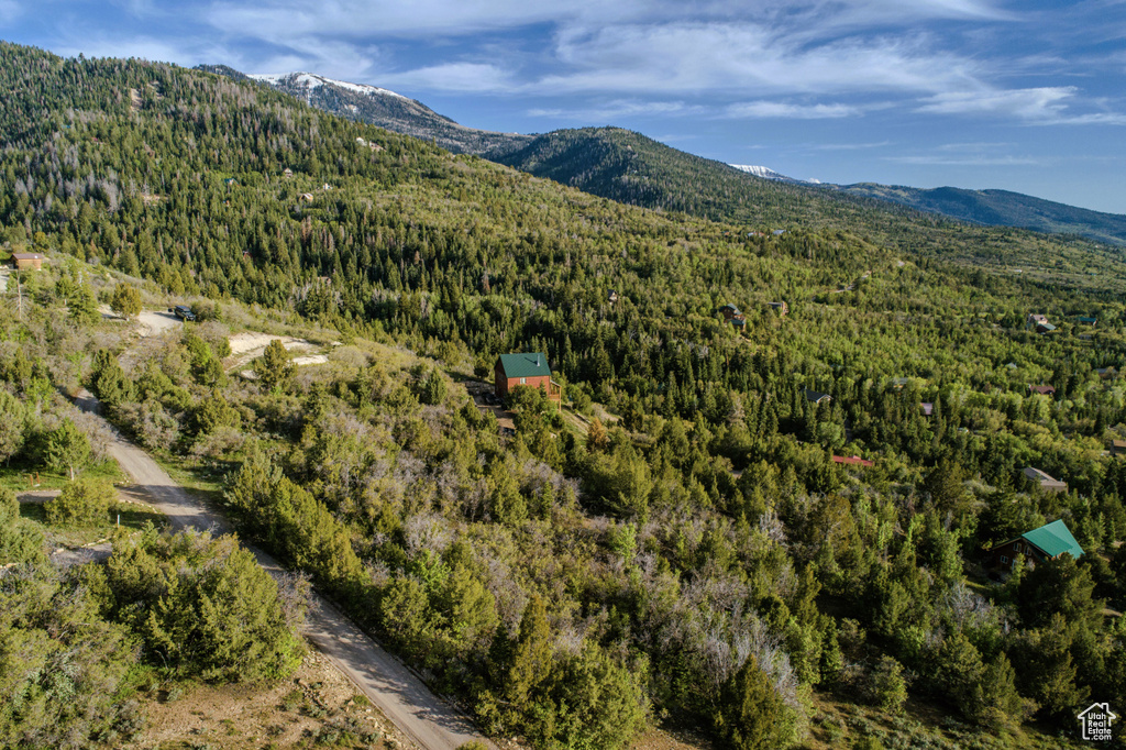 Aerial view of property and surrounding area with a heavily wooded area and mountains