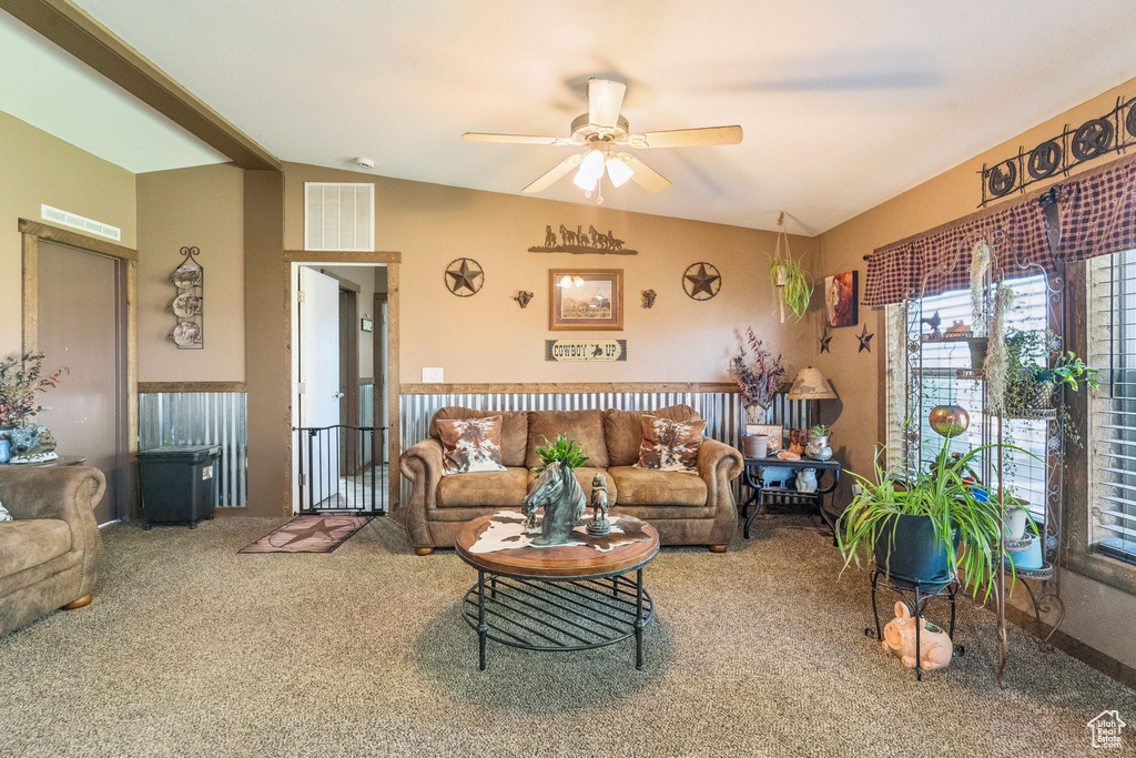 Living area with vaulted ceiling, carpet floors, and a ceiling fan