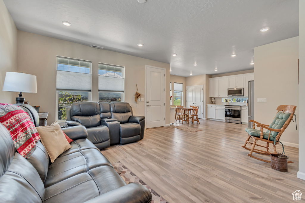 Living room featuring light wood-style floors, recessed lighting, and baseboards
