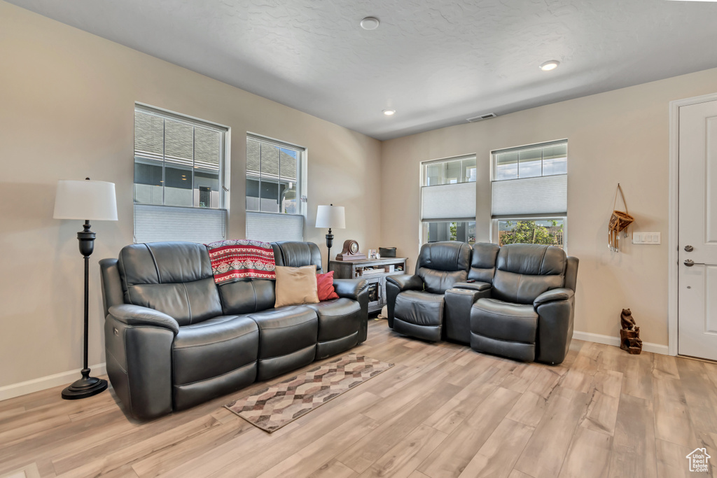 Living room featuring light wood finished floors, baseboards, and recessed lighting