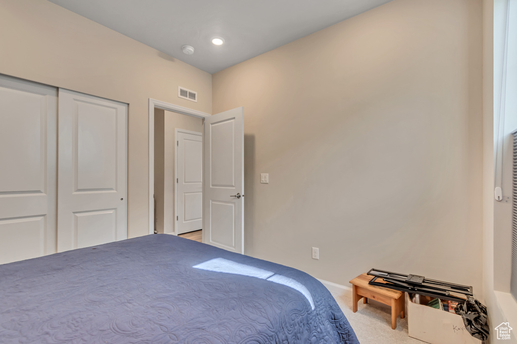 Bedroom with carpet, baseboards, and a closet
