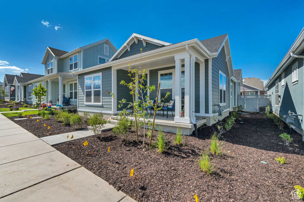 View of front of property with covered porch, board and batten siding, a residential view, and roof with shingles