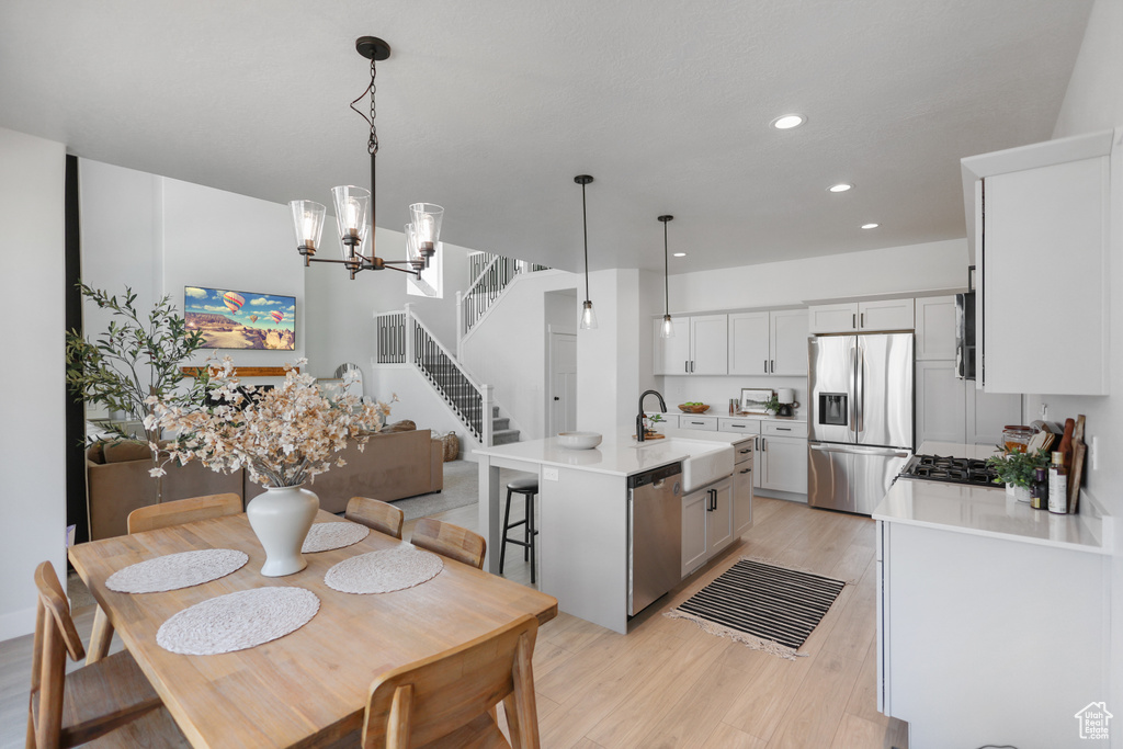Dining room featuring light wood-type flooring, recessed lighting, a chandelier, and stairway