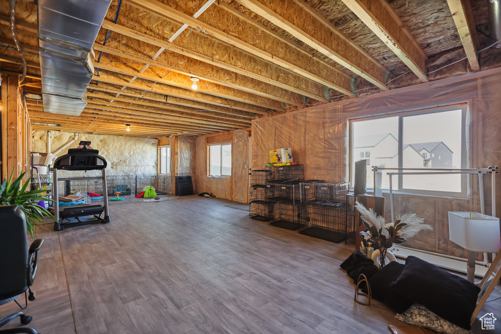 Basement with wood finished floors and a baseboard radiator