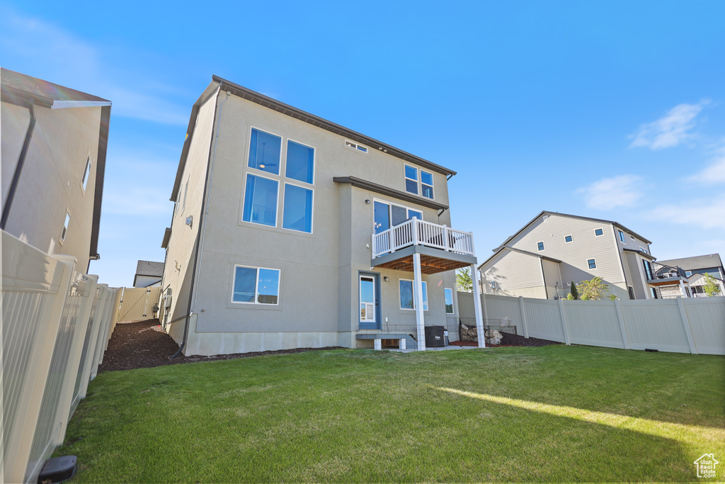 Rear view of house with a balcony and stucco siding