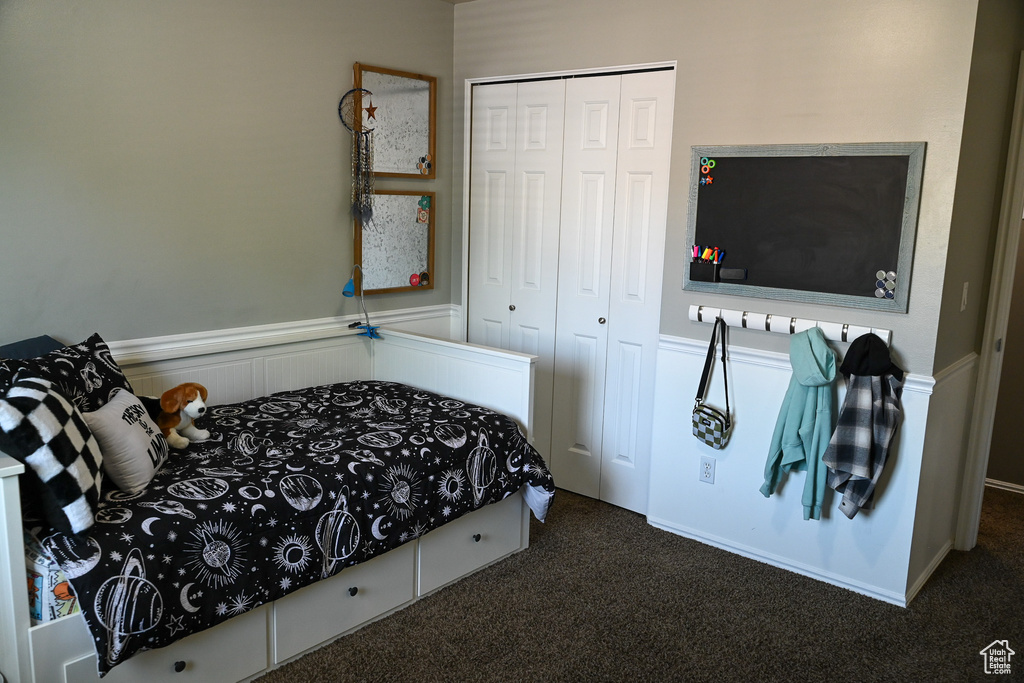 Bedroom featuring carpet flooring, a closet, and a wainscoted wall