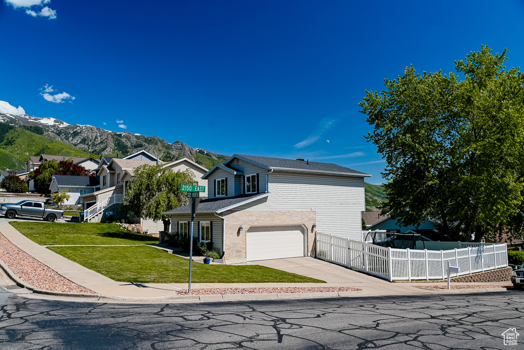 View of front facade with driveway, an attached garage, and a mountain view