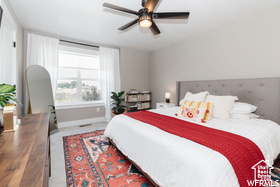 Carpeted bedroom featuring baseboards and a ceiling fan