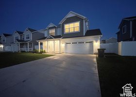 View of front of home featuring concrete driveway, a garage, and a residential view