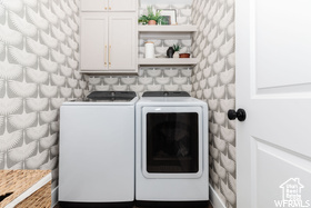 Laundry area with cabinet space and washing machine and clothes dryer