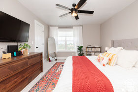 Carpeted bedroom featuring a ceiling fan and baseboards