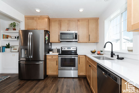 Kitchen featuring stainless steel appliances, a sink, light countertops, and recessed lighting