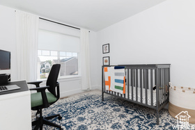 Bedroom featuring a desk and a crib