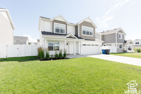 View of front of house with an attached garage, concrete driveway, and a residential view