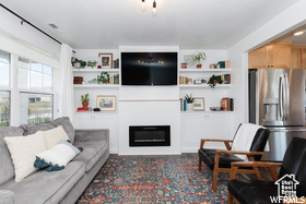 Living room with a glass covered fireplace and built in shelves