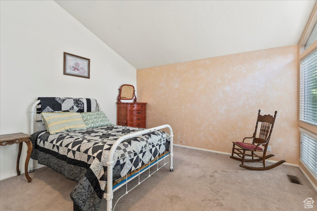Bedroom with carpet floors, vaulted ceiling, and baseboards